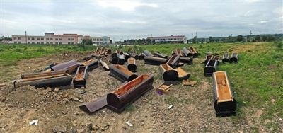 40多副棺木被砸壞后，扔在荒地上。