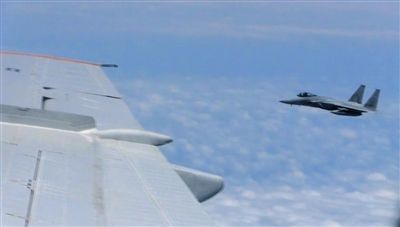國防部網(wǎng)站12日公布的視頻截圖,日本F-15軍機從中國圖-154機頭方向危險切入,兩者最近距離約30米左右。