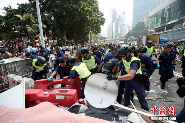10月14日，警方清除金鐘道障礙物。大批警員在金鐘道現(xiàn)場清拆障礙物。部分警員戴上頭盔將障礙物移走。