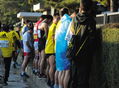 2013年10月20日，北京馬拉松比賽，由于廁位有限，一些選手在綠化帶“就地解決”。圖/IC