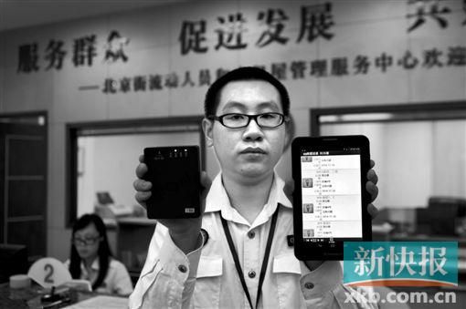 　越秀區(qū)北京街出租屋外來(lái)暫住人員管理服務(wù)中心的工作人員展示到出租屋登記來(lái)穗人員信息的儀器。