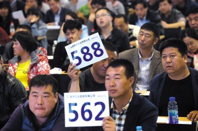 昨日，拍賣現(xiàn)場競拍者舉牌競拍。新京報(bào)記者