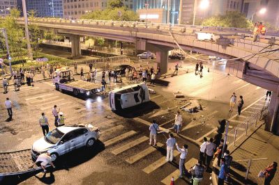路虎沖下國貿(mào)橋砸中一輛起亞轎車，橋上厚達幾十厘米的水泥護欄被撞斷，碎石四處散落，數(shù)十群眾在現(xiàn)場圍觀。