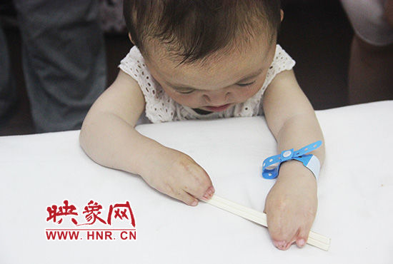 孩子握著筷子發(fā)呆。