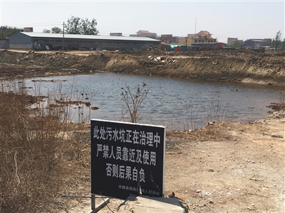 化肥廠滲坑的三分之一經(jīng)過(guò)治理，但水質(zhì)仍然呈黃褐色。
