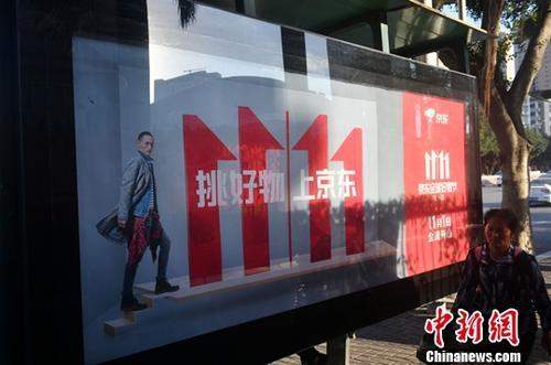 資料圖：11月1日，福州民眾從雙十一廣告牌前經(jīng)過。中新社記者 呂明 攝