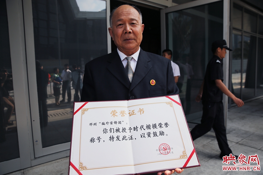 河南鄧州“編外雷鋒團(tuán)”團(tuán)長宋清梅向眾多記者展示中宣部授予的“時(shí)代楷?！睒s譽(yù)證書。