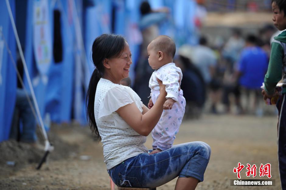 8月6日，一名年輕的母親在和孩子玩樂。