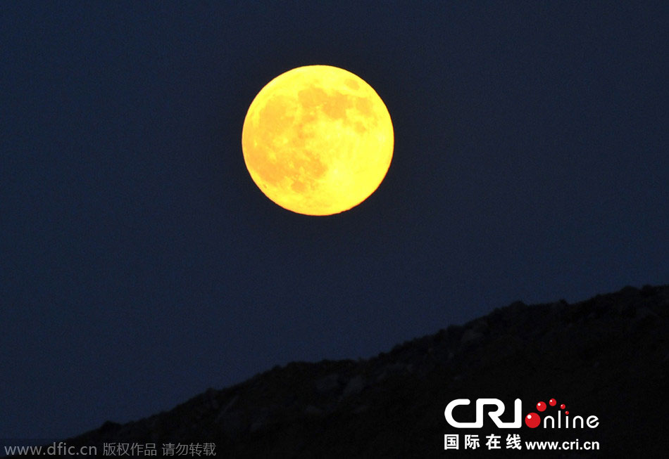 8月10日晚，一輪金燦燦的大月亮在遼寧省大連市東方升起。圖片來源：劉德斌/東方IC