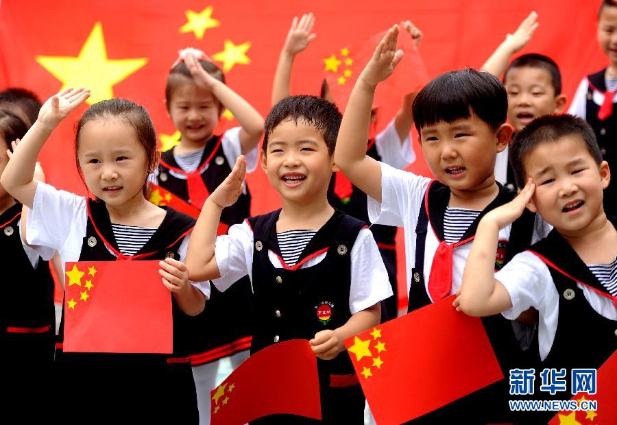  9月28日，安徽淮南市直機關(guān)幼兒園的小朋友在國旗前唱《國歌》，慶祝祖國65周歲生日。