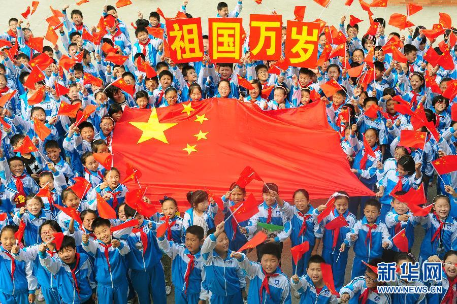 9月26日，安徽省阜陽市北城小學(xué)分校的學(xué)生與國旗合影。