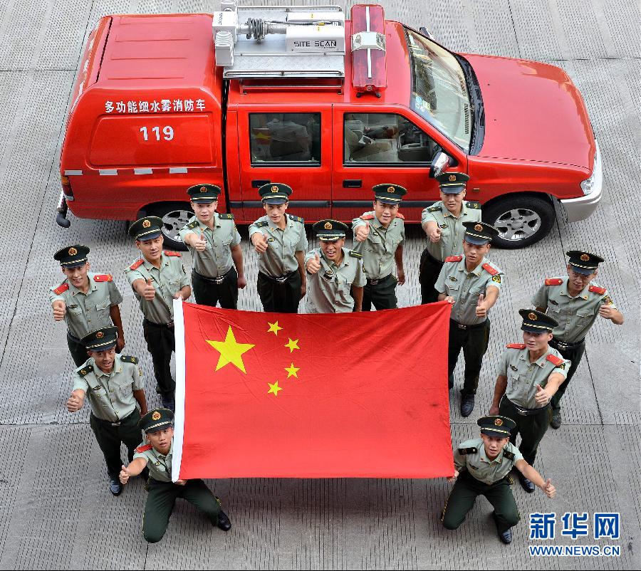  9月25日，武警浙江嘉興消防官兵與國旗合影。