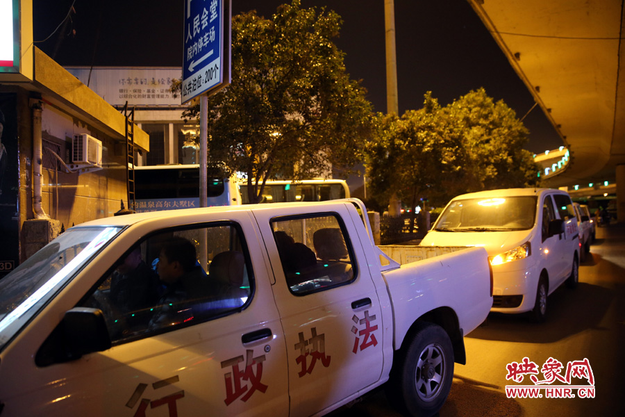 會(huì)堂旁停放著數(shù)輛行政執(zhí)法車