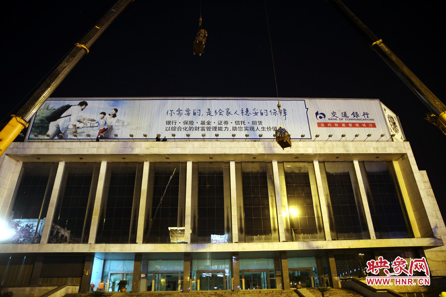 兩輛吊車向會(huì)堂屋頂運(yùn)輸氣鋼瓶和施工人員