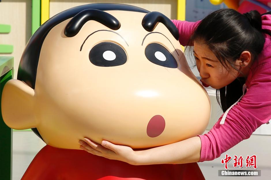 4月22日，游客與蠟筆小新合影。“蠟筆小新25周年紀(jì)念特展”日前在北京開展，吸引了不少市民游客。