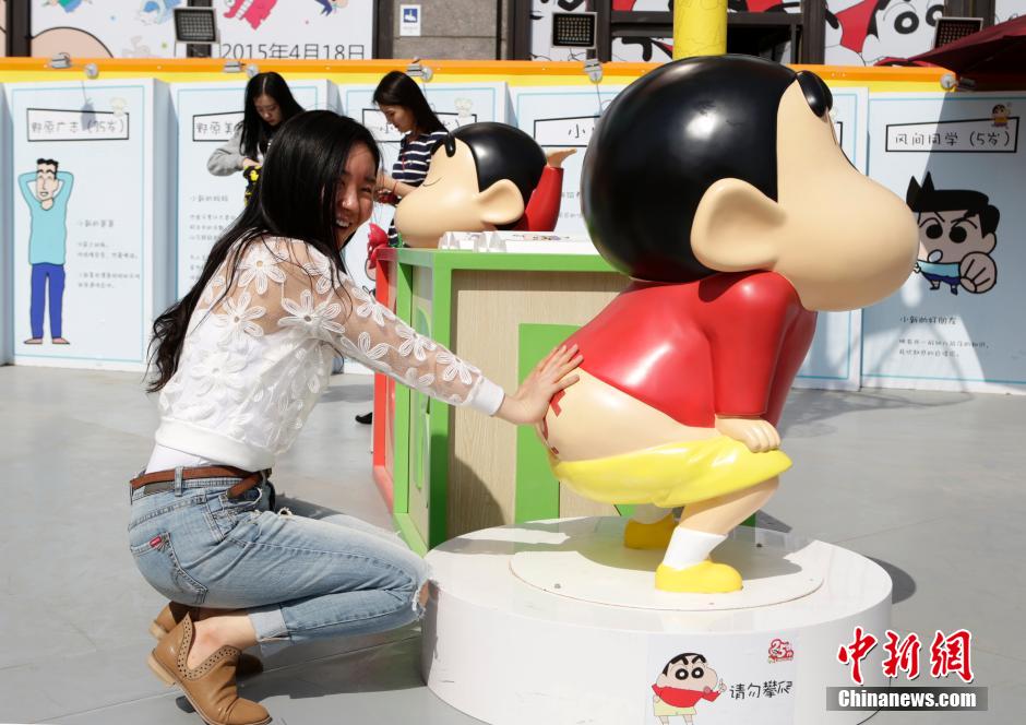 4月22日，游客與蠟筆小新合影?！跋灩P小新25周年紀(jì)念特展”日前在北京開展，吸引了不少市民游客。