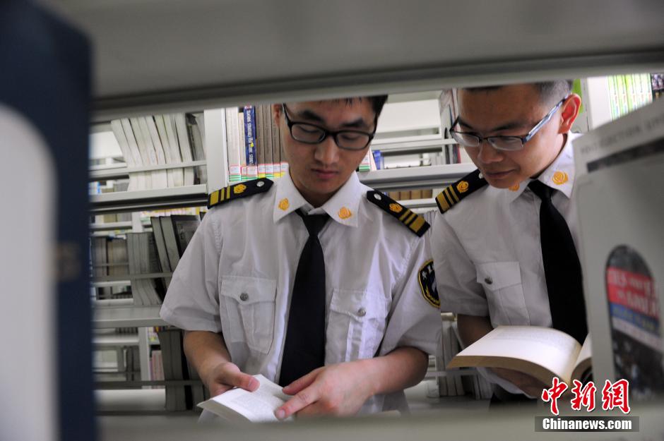 5月8日，武漢輕工大學(xué)圖書館保安吳濤與江力在圖書館交流學(xué)習(xí)。