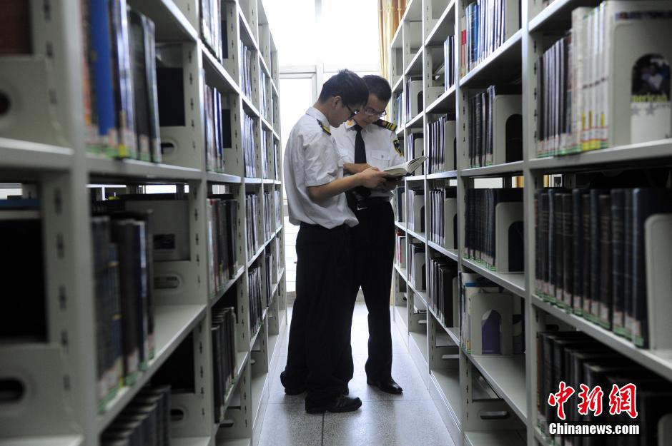 5月8日，武漢輕工大學(xué)保安吳濤與江力在圖書館交流學(xué)習(xí)。中新社發(fā) 張暢 攝