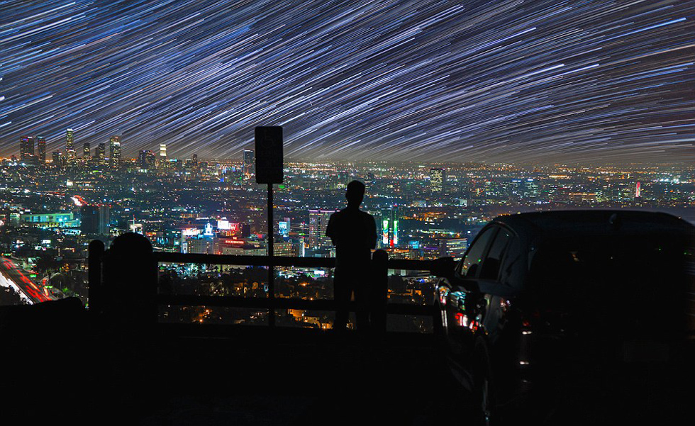 照片中，一名男子看著流星和隕星劃過天空。（網(wǎng)頁截圖）