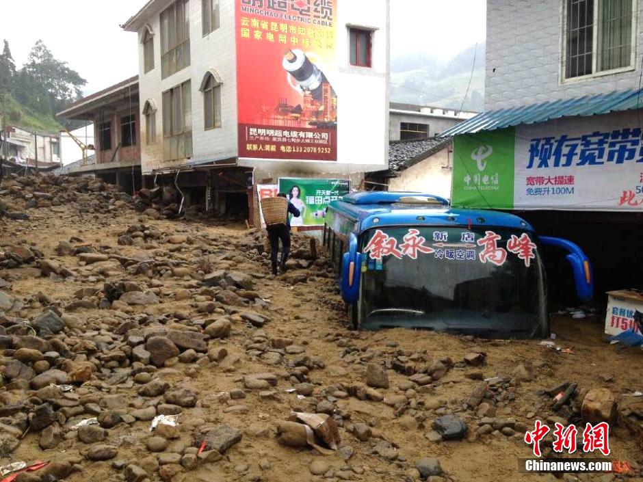 圖為山洪泥石流導沖進鄉(xiāng)鎮(zhèn)街道，導致客車被埋。