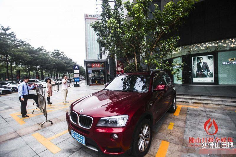 一輛停在停車位上的寶馬轎車，被墜落的樹枝砸中，樹枝徑直插入車內(nèi)，現(xiàn)場(chǎng)引發(fā)不少市民圍觀拍照。