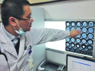 醫(yī)生在查看男孩的腦部CT片。薛馬義 攝