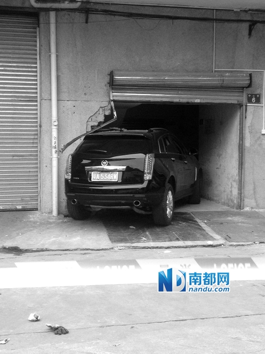 　昨日，凱迪拉克撞人后停在一倉(cāng)庫(kù)門口，車后有一攤血跡。 南都記者陳杰生攝