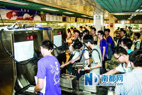 昨日，華南理工大學(xué)一食堂內(nèi)，學(xué)生們正在使用新安裝的自動(dòng)打飯機(jī)打飯。中新社發(fā)