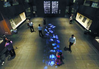 昨天，在國(guó)家典籍博物館內(nèi)，通過(guò)藝術(shù)投影技術(shù)呈現(xiàn)在展廳地面上的“漢字歷史長(zhǎng)河”，引得參觀者駐足觀看。