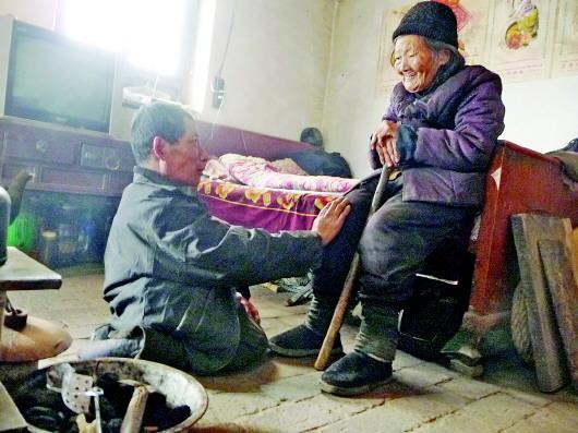 52歲的劉蘭山每天靠爬行照顧90歲的老母親。孫國祥 攝