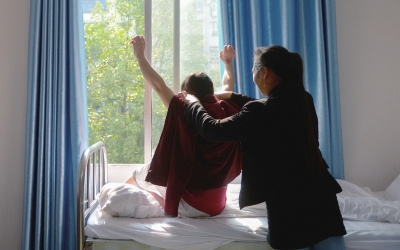 出院前，窗外透進(jìn)一道陽光，打在他的身上。