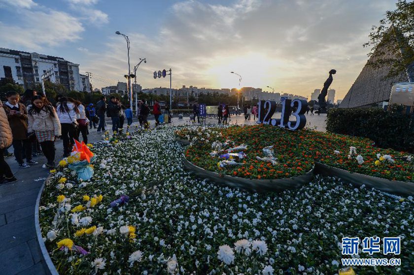 12月14日,觀眾在侵華日軍南京大屠殺遇難同胞紀(jì)念館前的“12·13”花壇上擺放鮮花祭奠遇難同胞。新華社記者 沈鵬 攝