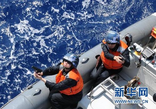 　3月28日，十余名臨檢拿捕隊員乘小艇駛至模擬可疑商船下方水面。