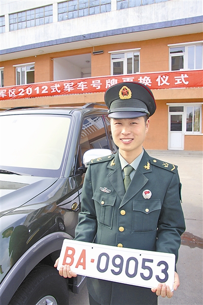 駐京某部長途汽車隊中士王志濤領(lǐng)到新式軍車號牌。