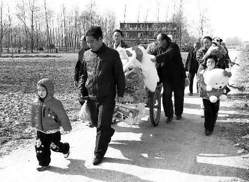姐（左一）弟（右一護(hù)士懷中男嬰）返鄉(xiāng)，愛心捐贈(zèng)滿滿一架子車。