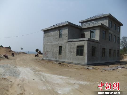 鴨河水庫(kù)庫(kù)區(qū)邊的新建別墅，一面墻上寫(xiě)著“拆”，另一邊在加緊施工。吳揚(yáng)　攝