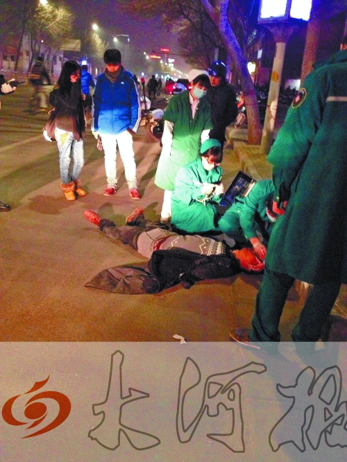 醉漢躺在地上，醫(yī)護人員對其進行檢查。